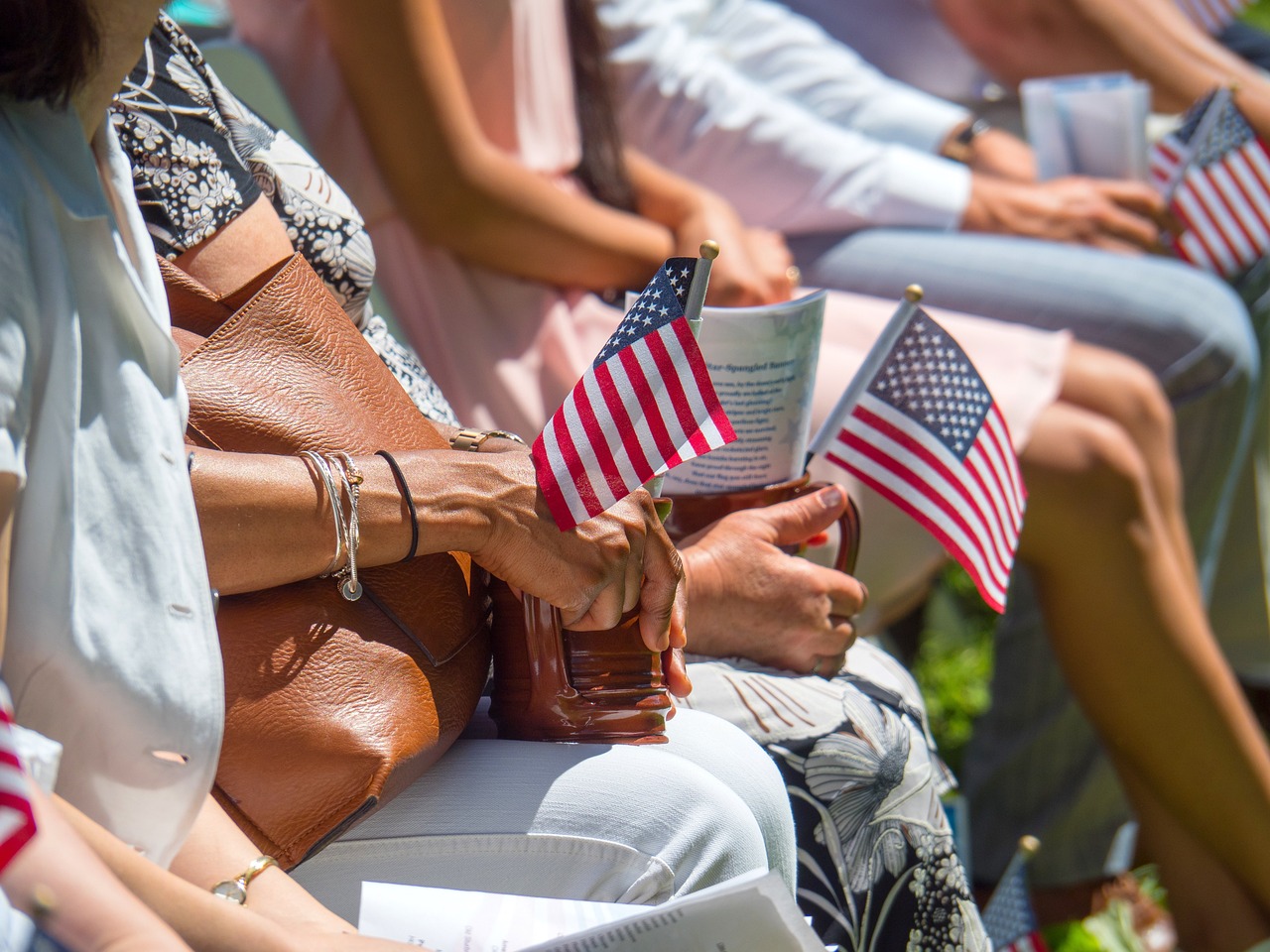 An elderly woman holding American flags